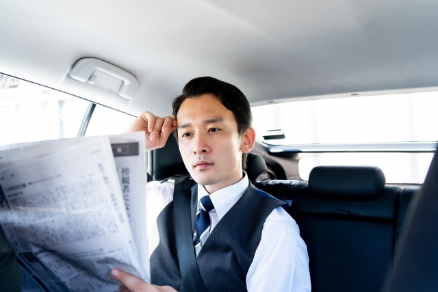 新聞を読むタクシー運転手